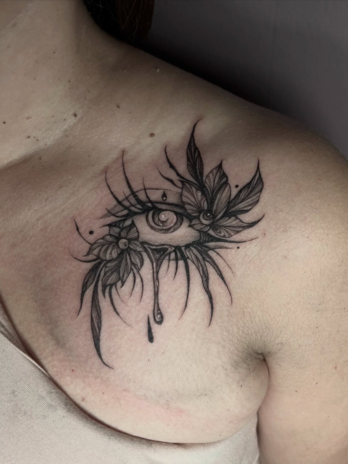 Oeil ornemental rayonnant blackwork sur le buste
